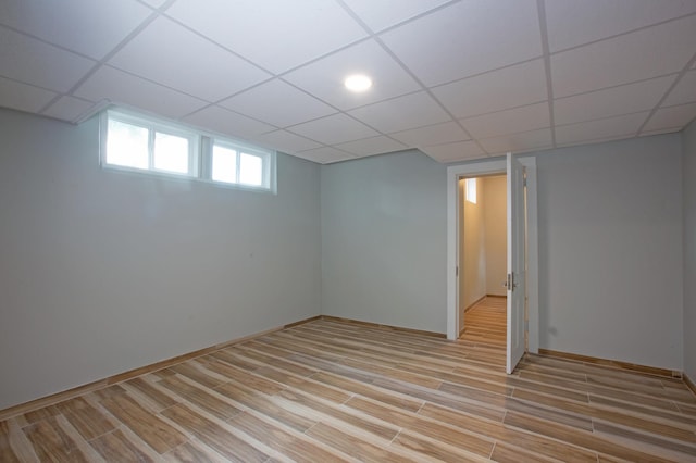 basement with light wood-type flooring and a drop ceiling