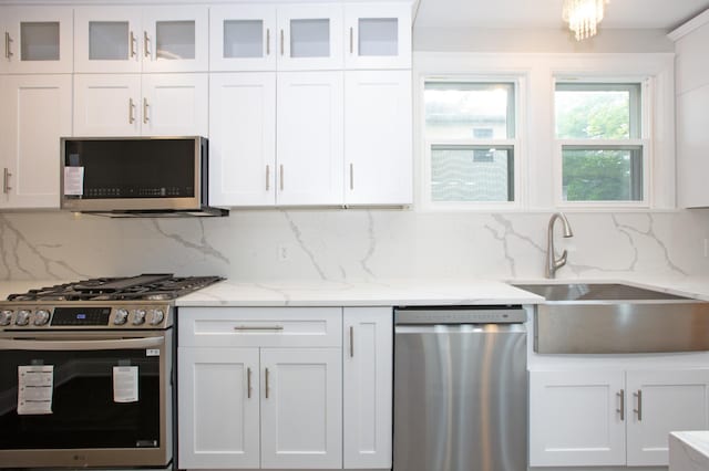 kitchen featuring white cabinets, decorative backsplash, and stainless steel appliances