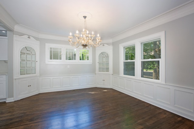 unfurnished dining area featuring dark wood-type flooring, crown molding, and an inviting chandelier