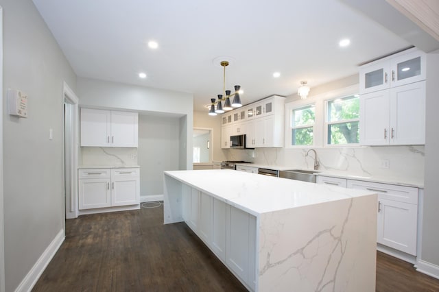 kitchen featuring hanging light fixtures, white cabinetry, sink, and appliances with stainless steel finishes