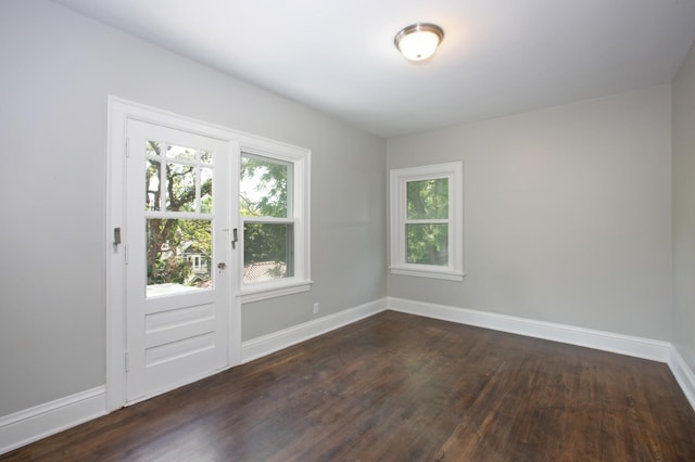 unfurnished room with dark hardwood / wood-style flooring