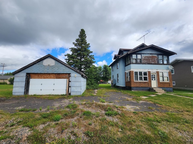 view of property exterior featuring an outbuilding, a yard, and a garage