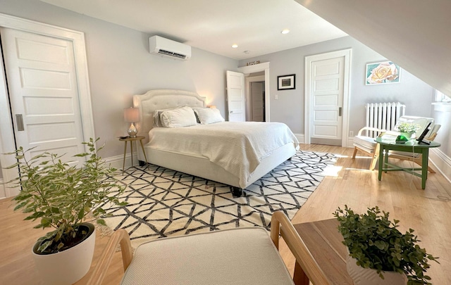 bedroom featuring a wall mounted AC, light wood-type flooring, and radiator