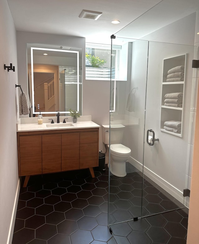 bathroom featuring vanity, toilet, tile patterned floors, and a shower with door