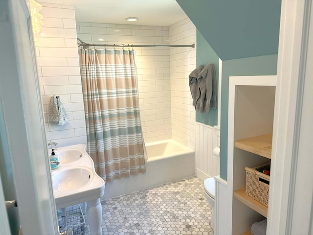 bathroom with toilet, dual sinks, shower / bath combo with shower curtain, and tile patterned floors