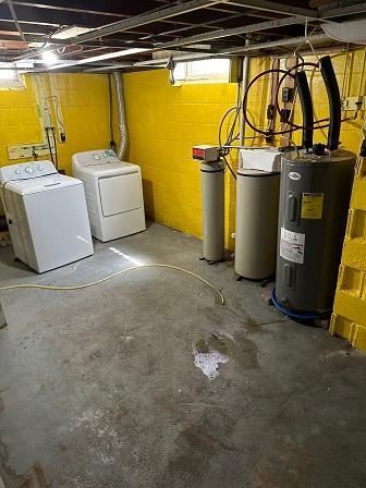 basement with water heater and washer and dryer