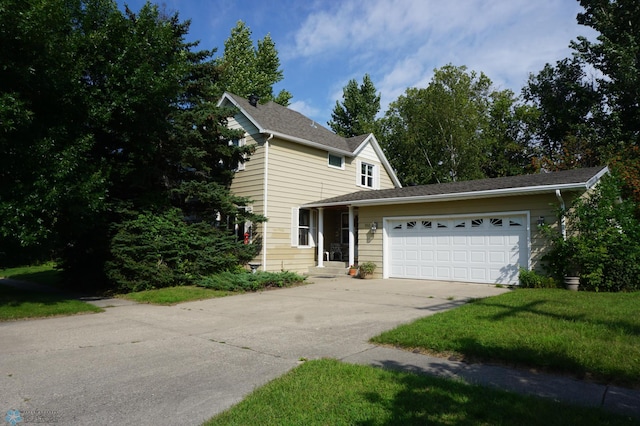 traditional-style home featuring a garage, a front yard, and concrete driveway