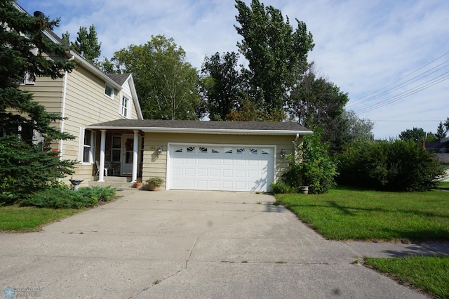 view of front facade featuring a front yard, concrete driveway, and an attached garage