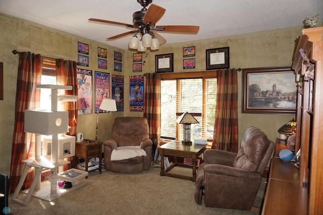 living area with ceiling fan and carpet flooring