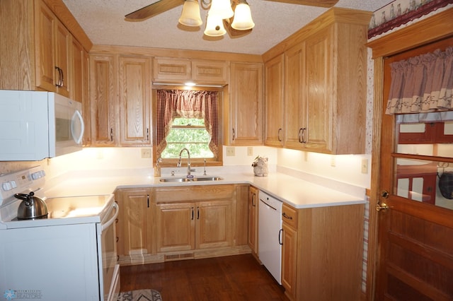 kitchen featuring a textured ceiling, light brown cabinets, white appliances, a sink, and light countertops