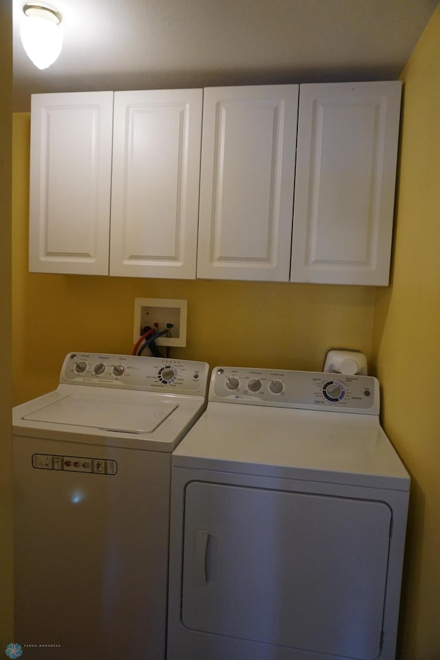 washroom featuring separate washer and dryer and cabinet space