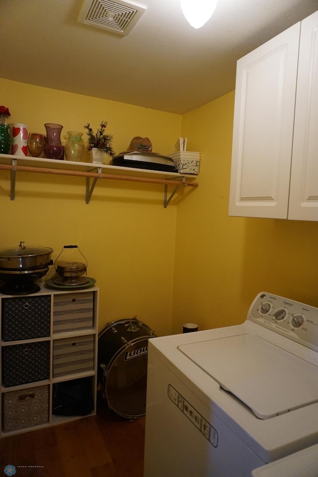 clothes washing area with cabinet space, visible vents, washer / clothes dryer, and dark wood-style flooring