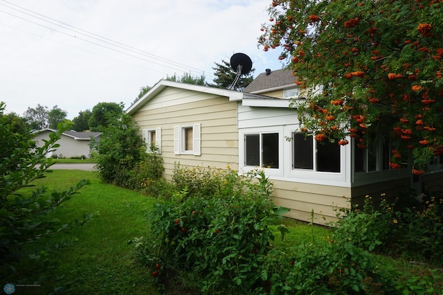 view of property exterior with a lawn