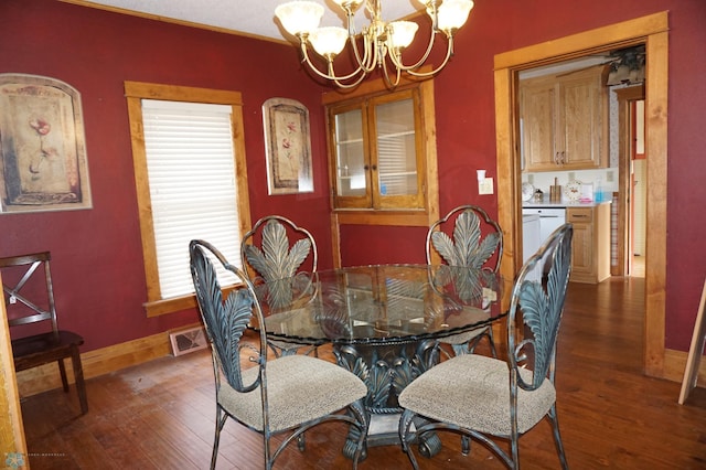 dining space with a chandelier, dark wood-type flooring, visible vents, and baseboards