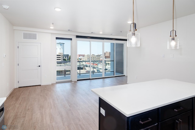 kitchen featuring hanging light fixtures, light hardwood / wood-style flooring, and a center island