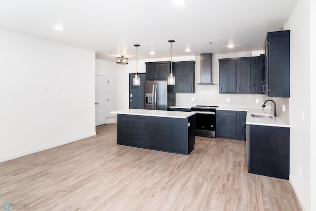 kitchen featuring a center island, sink, wall chimney range hood, pendant lighting, and appliances with stainless steel finishes