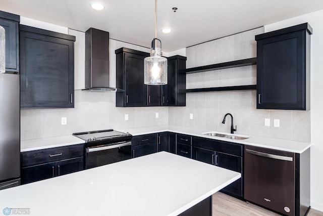 kitchen with stainless steel appliances, sink, wall chimney exhaust hood, light wood-type flooring, and pendant lighting