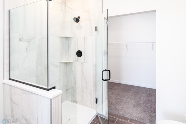 bathroom featuring hardwood / wood-style floors and a shower with shower door