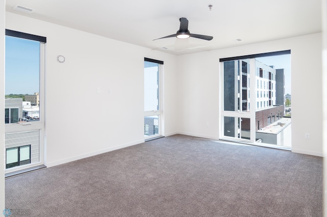 unfurnished room featuring carpet floors, plenty of natural light, and ceiling fan