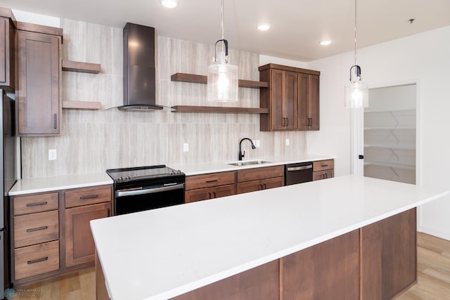 kitchen featuring black / electric stove, pendant lighting, light hardwood / wood-style floors, wall chimney exhaust hood, and sink