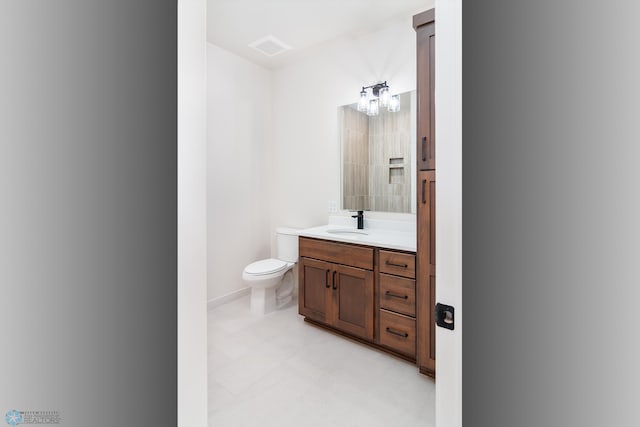 bathroom with vanity, a notable chandelier, and toilet