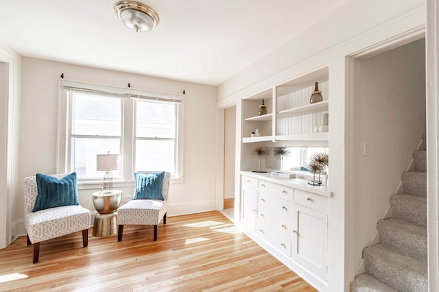 sitting room with built in features and light wood-type flooring