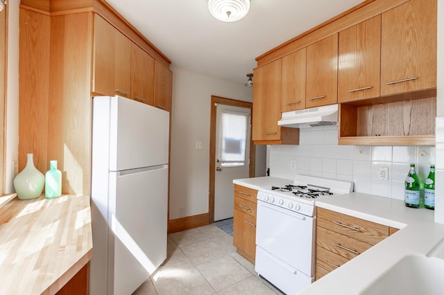 kitchen with light tile patterned floors, decorative backsplash, and white appliances