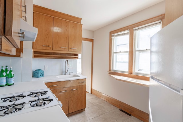 kitchen with backsplash, sink, white refrigerator, light tile patterned floors, and wall chimney range hood