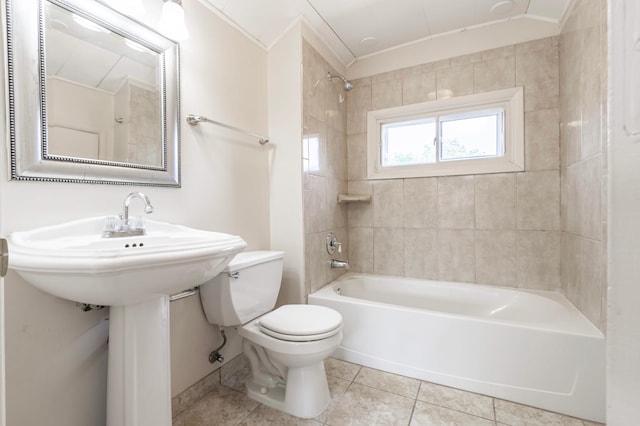 bathroom featuring tile patterned flooring, toilet, tiled shower / bath combo, and ornamental molding