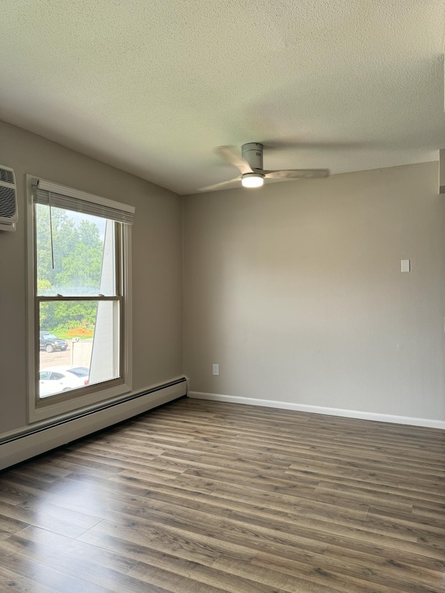 unfurnished room with baseboards, a baseboard heating unit, dark wood finished floors, and a ceiling fan