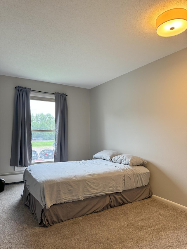 bedroom with carpet floors, a baseboard radiator, and baseboards