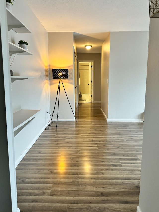 interior space with baseboards and wood finished floors