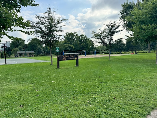 surrounding community with volleyball court, a lawn, and community basketball court