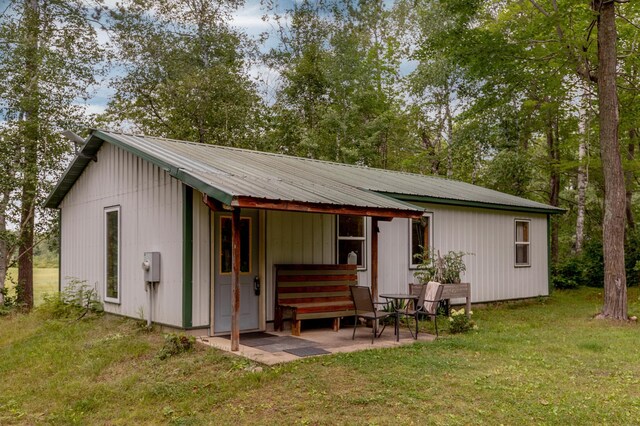 back of house with a patio area and a yard