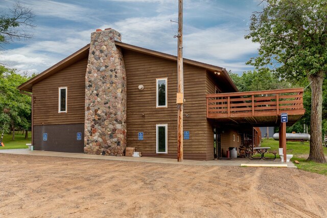 back of property featuring a chimney and a wooden deck