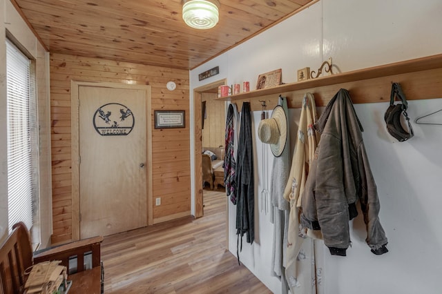 mudroom featuring light wood-style floors, wood ceiling, and wooden walls