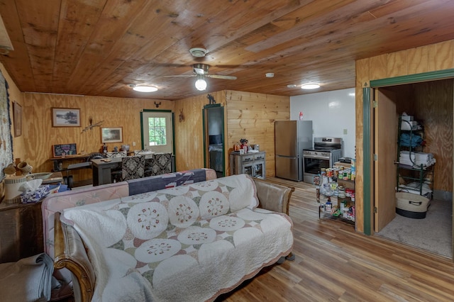 living room with wood ceiling, wooden walls, light wood-style flooring, and a ceiling fan