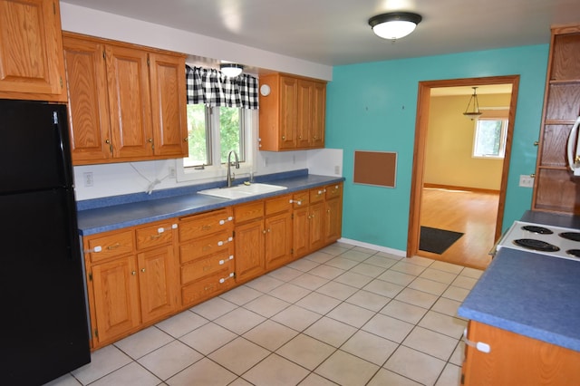 205 2nd Ave SE, Baudette, MN 56623 - kitchen with freestanding refrigerator, healthy amount of natural light, brown cabinets, and dark countertops