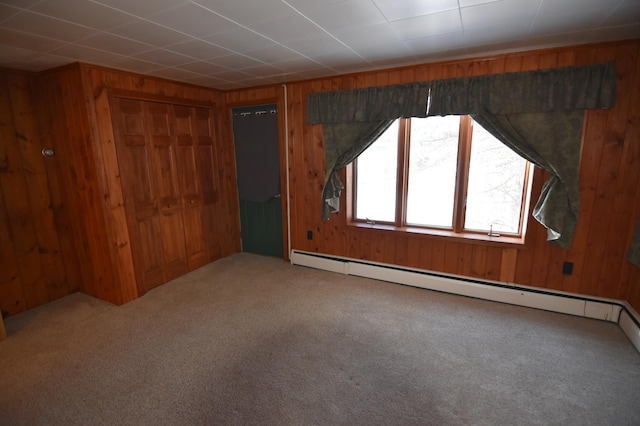 205 2nd Ave SE, Baudette, MN 56623 - unfurnished bedroom with wood walls, carpet floors, a closet, and baseboard heating