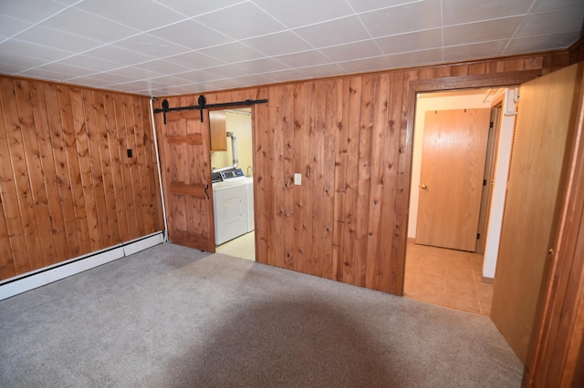 205 2nd Ave SE, Baudette, MN 56623 - empty room featuring washer / clothes dryer, a barn door, wooden walls, carpet flooring, and a baseboard radiator
