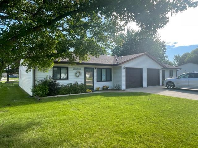 ranch-style house with a garage and a front lawn