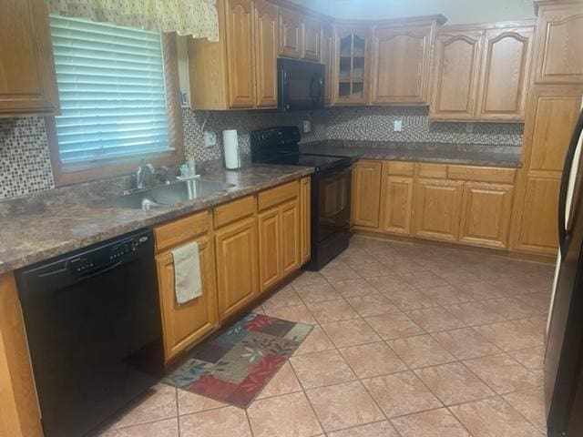 kitchen featuring black appliances, light tile patterned flooring, tasteful backsplash, and sink