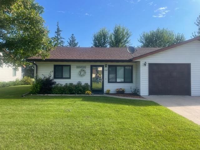 single story home with a garage and a front lawn