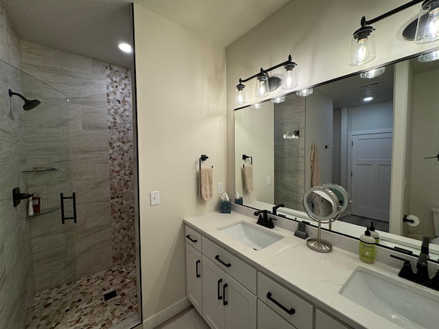 bathroom featuring vanity, an enclosed shower, and a textured ceiling