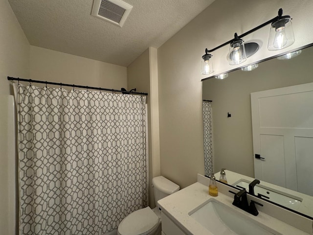 bathroom with vanity, walk in shower, a textured ceiling, and toilet