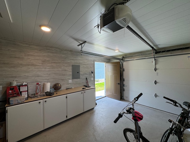 garage featuring a garage door opener, electric panel, and wooden walls