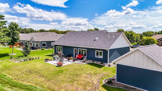 rear view of property with a patio and a lawn