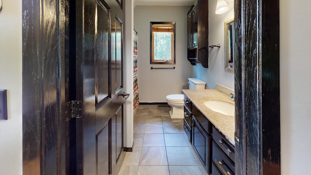 bathroom featuring vanity, tile patterned flooring, and toilet