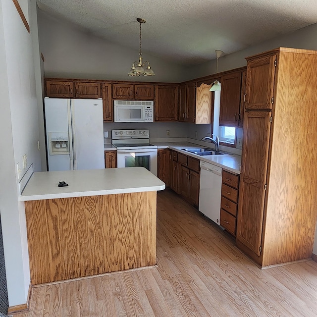 kitchen with sink, light wood-type flooring, pendant lighting, lofted ceiling, and white appliances