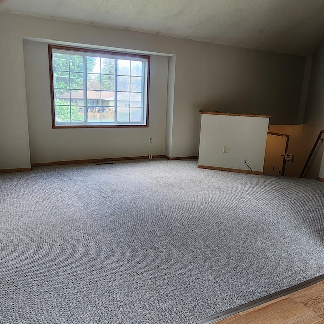 carpeted spare room with a textured ceiling